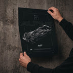 Alpine A424 2023 poster print held in hands against a concrete wall