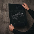 Aston Martin Ulster 1935 poster print held in hands against a concrete wall