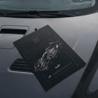 BMW M Hybrid V8 WEC 2024 poster resting on a car hood