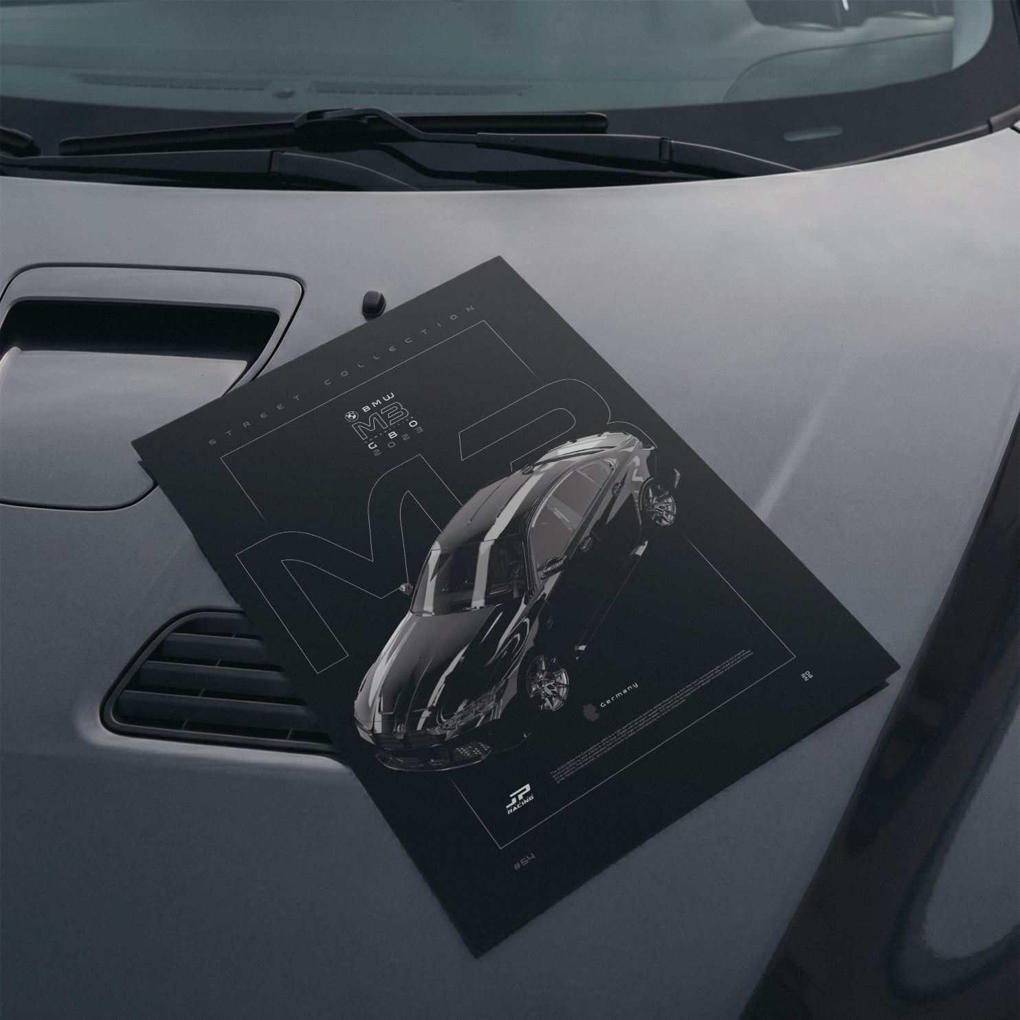 BMW M3 Competition G80 2023 poster resting on a car hood